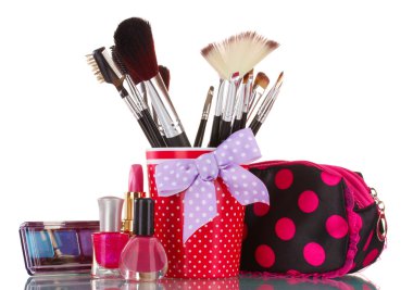 Red glass with brushes and makeup bag with cosmetics isolated on white clipart