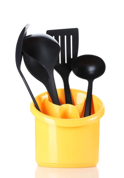 Utensili da cucina neri in stand giallo isolato su bianco — Foto Stock
