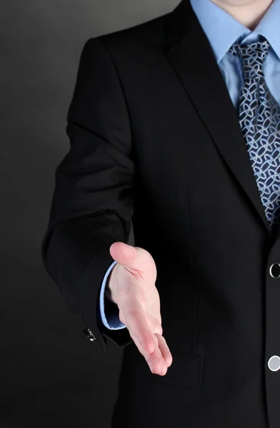 Бізнесмен дає руку для рукостискання на чорному тлі — стокове фото