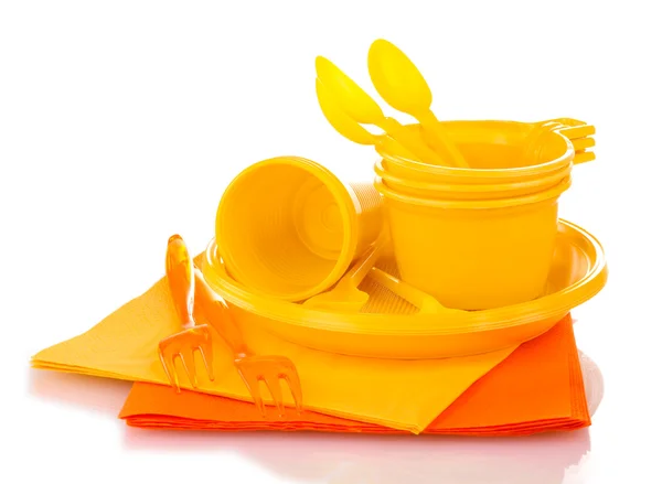 Bright yellow plastic tableware and napkins isolated on white — Stock Photo, Image