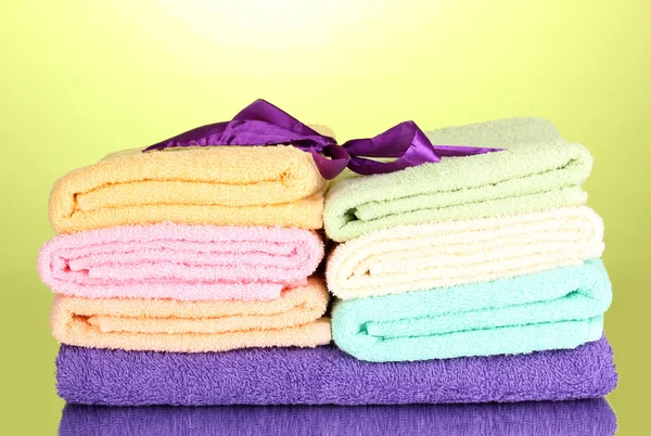 Asciugamani colorati con nastro su sfondo verde — Foto Stock