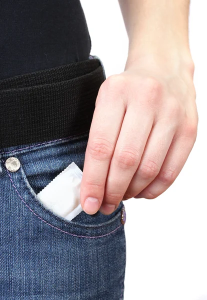Flicka dra ut kondom från hennes jeans ficka på nära håll — Stockfoto