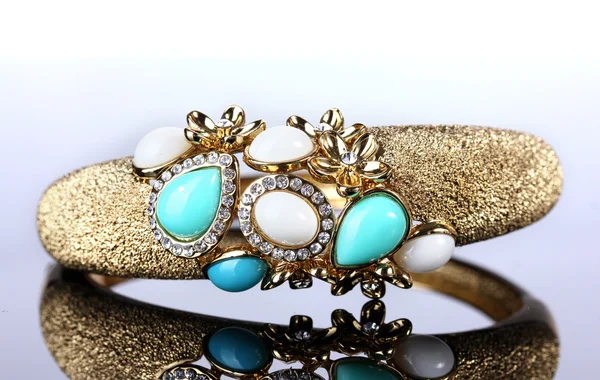 Schönes goldenes Armband mit Edelsteinen auf grauem Hintergrund — Stockfoto