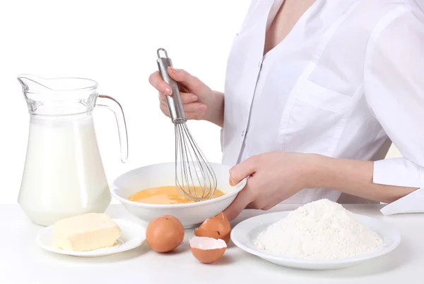 Weibliche Hände vermischen Eier in Schüssel isoliert auf weiß — Stockfoto