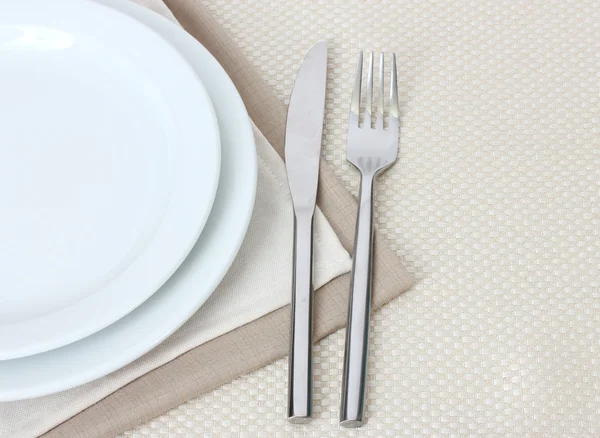 Ajuste de mesa con tenedor, cuchillo, platos y servilleta — Foto de Stock