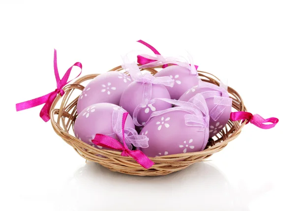 Цветные пасхальные яйца в корзине изолированы на белом — стоковое фото