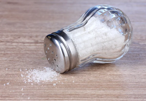 Glassalzkeller mit Salz auf Holzgrund — Stockfoto