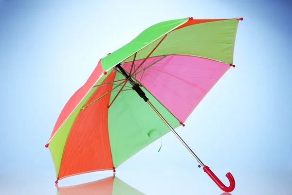 Parapluie multicolore sur fond bleu — Photo