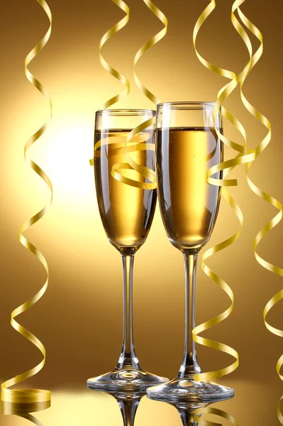 Sklenice šampaňského a stuhami na žlutém podkladu — Stock fotografie
