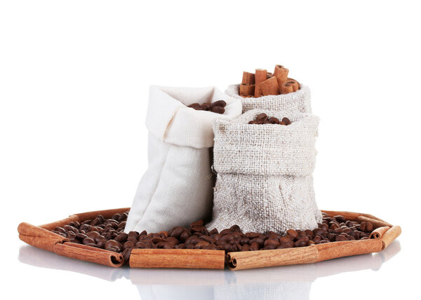 Coffee beans and cinnamon in canvas sacks isolated on white