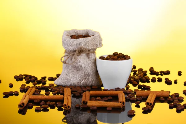 Composition of canvas sack and the cup with coffee beans on bright background. Hot. — Stock Photo, Image