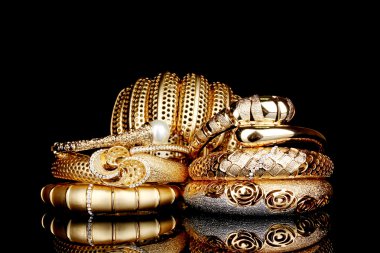 Beautiful golden bracelets isolated on black background clipart