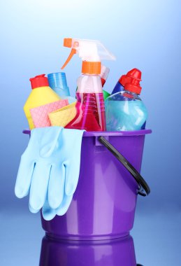 Bucket with cleaning items on blue background clipart