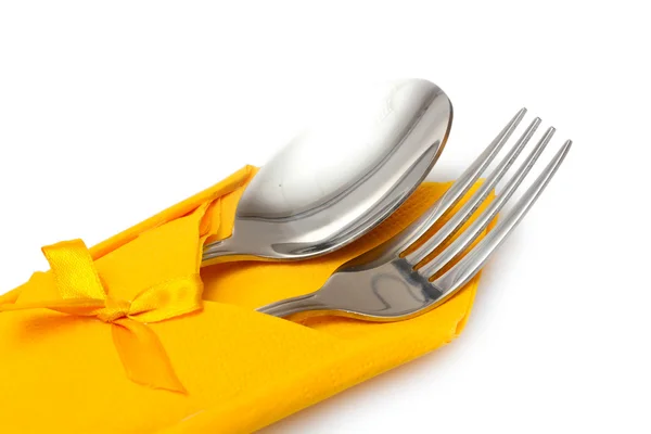 Garfo e colher em um pano amarelo com um arco isolado no branco — Fotografia de Stock