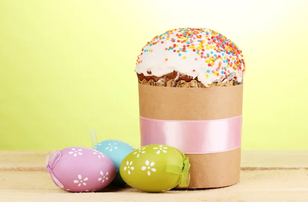 Krásné velikonoční dort se vejce na dřevěný stůl na zeleném pozadí — Stock fotografie