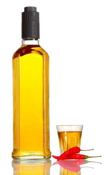 Láhve a sklenice pepř vodky a červené chilli papričky izolované na bílém — Stock fotografie