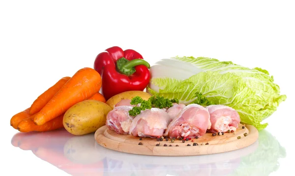 Verduras frescas con palitos de pollo crudos y filete de cerdo en la tabla de cortar aislado en blanco —  Fotos de Stock