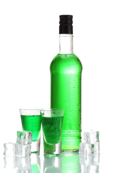 Láhve a sklenice absintu s ledem izolovaných na bílém — Stock fotografie