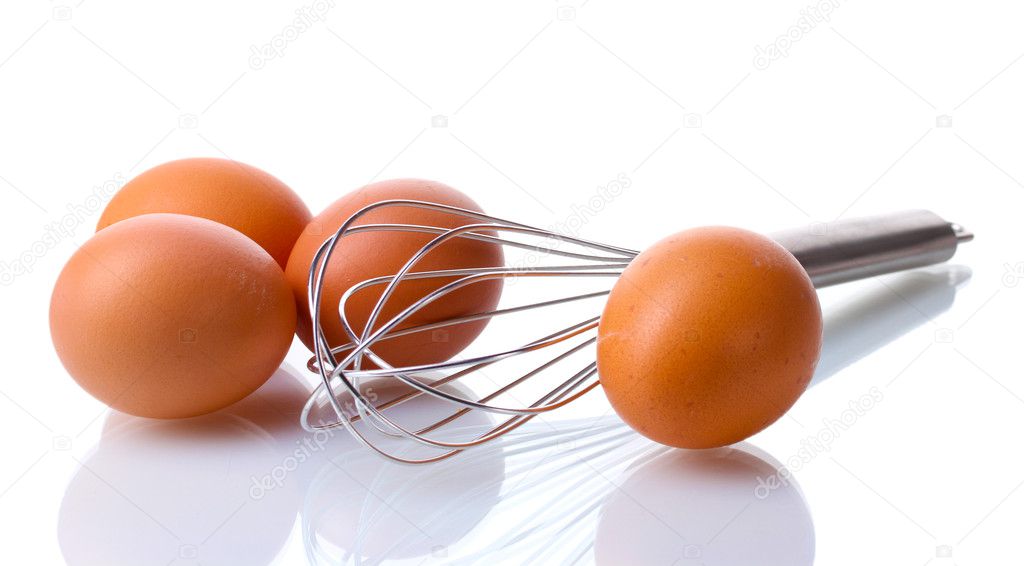 Metal whisk for whipping eggs and brown eggs isolated on white