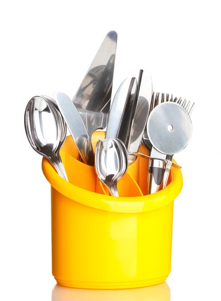 Posate da cucina, coltelli, forchette e cucchiai in stativo giallo isolato su bianco — Foto Stock