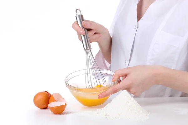 Γυναικεία χέρια Αναμιγνύοντας αυγά σε μπολ απομονώνονται σε λευκό — Φωτογραφία Αρχείου