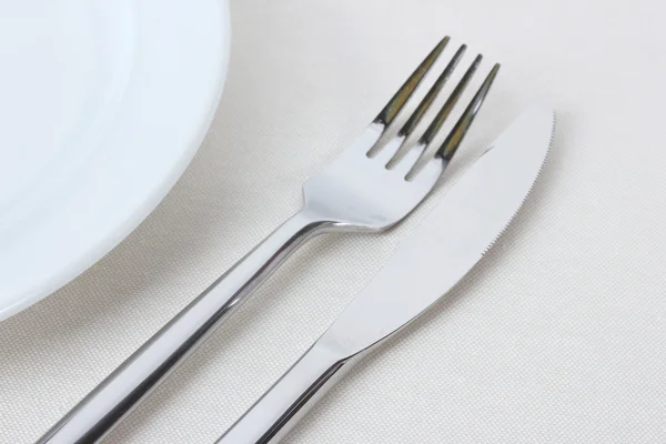 Tenedor, cuchillo y placa aislados en blanco — Foto de Stock