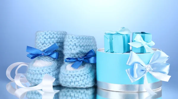Bellissimi regali e stivaletti del bambino su sfondo blu — Foto Stock