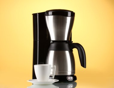 Coffee maker with white cup on yellow background clipart