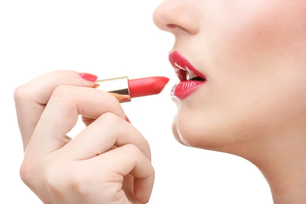 아름다운 여인이 붉은 립스틱으로 입술을 바르고 있다 — 스톡 사진