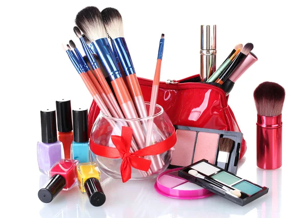 Cepillos de maquillaje en jarrón de vidrio y cosméticos aislados en blanco — Foto de Stock