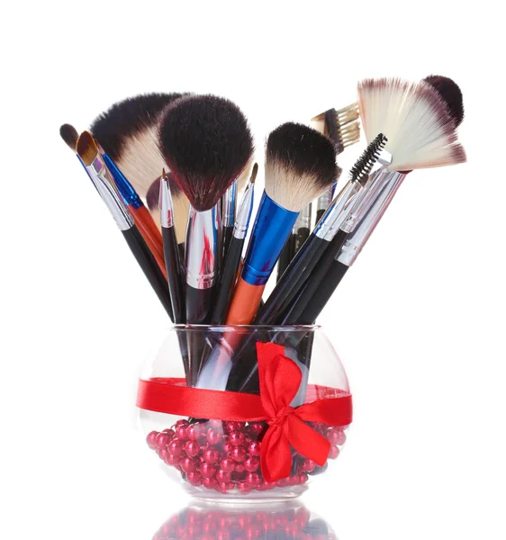 Cepillos de maquillaje en jarrón de vidrio aislado en blanco —  Fotos de Stock