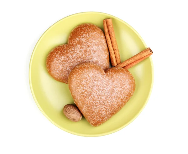 Biscotti a forma di cuore con cannella e noce moscata su piattino isolato su bianco — Foto Stock