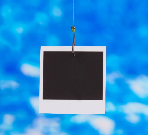 Photo on fish hook on blue background — Stock Photo, Image