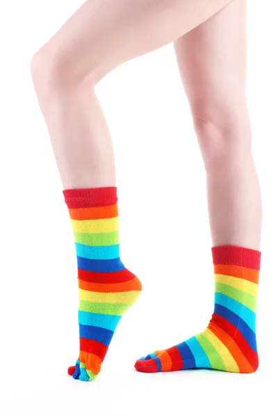 白で隔離されるカラフルなストライプ ソックスで女性の足 — ストック写真