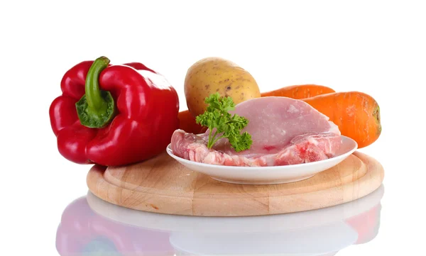Fresh vegetables and pork steak on cutting board isolated on white — Stock Photo, Image