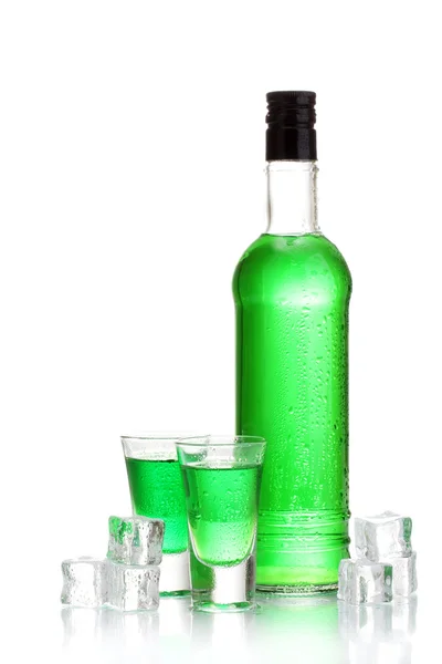 Bottle and glasses of absinthe with ice isolated on white — Stock Photo, Image