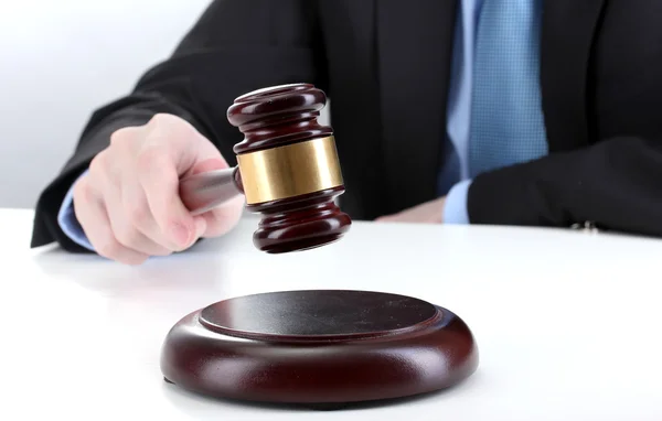 Wooden gavel in hand on gray background — Stock Photo, Image