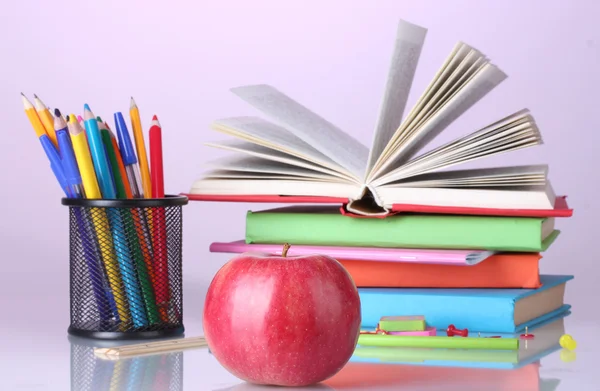 Skład książek, papeterii i jabłko na jasnym tle kolorowe — Zdjęcie stockowe