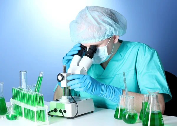 Scientist looking at microscope in chemistry laboratory Royalty Free Stock Photos