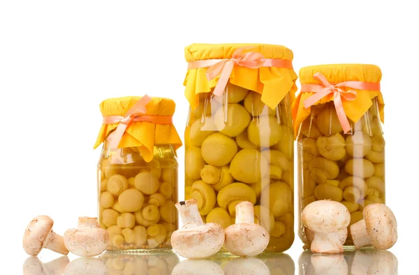 Deliciosos cogumelos marinados nos frascos de vidro e champinhons crus isolados em branco — Fotografia de Stock