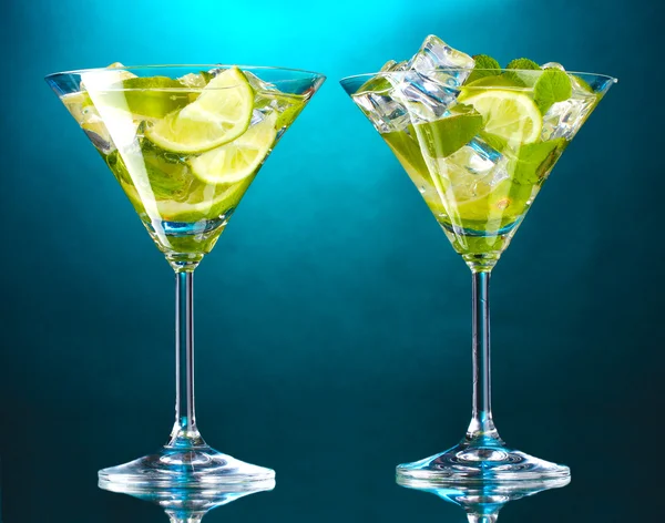 Cocktailgläser mit Limette und Minze auf blauem Hintergrund — Stockfoto