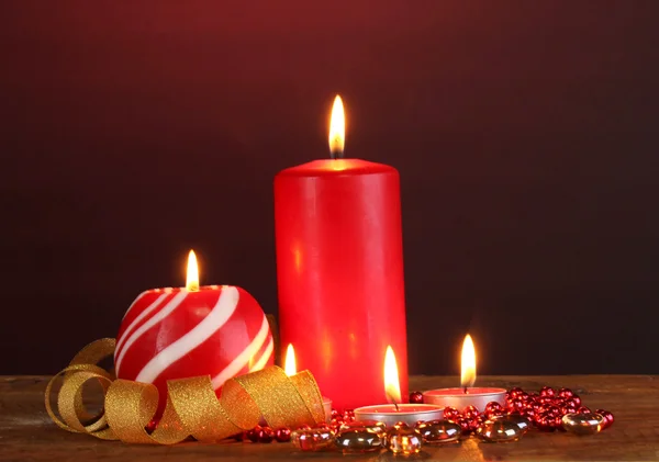 Nádherné svíčky na dřevěný stůl na tmavém pozadí — Stock fotografie