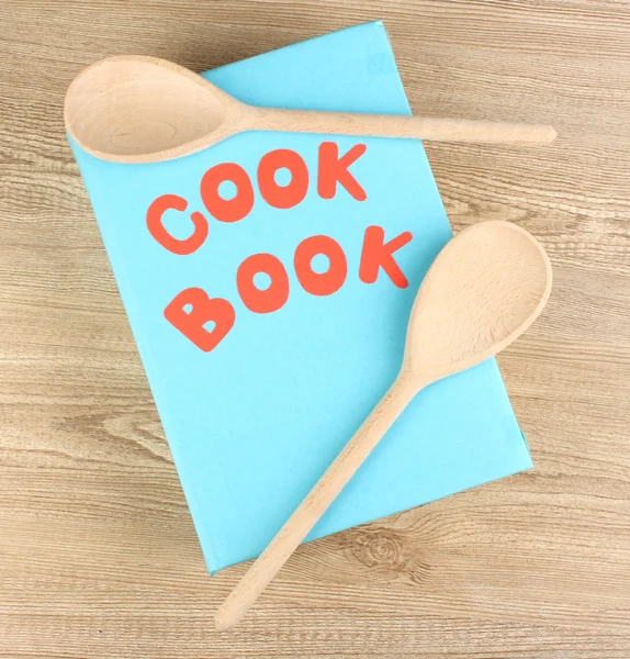Libro de cocina y utensilios de cocina sobre fondo de madera —  Fotos de Stock