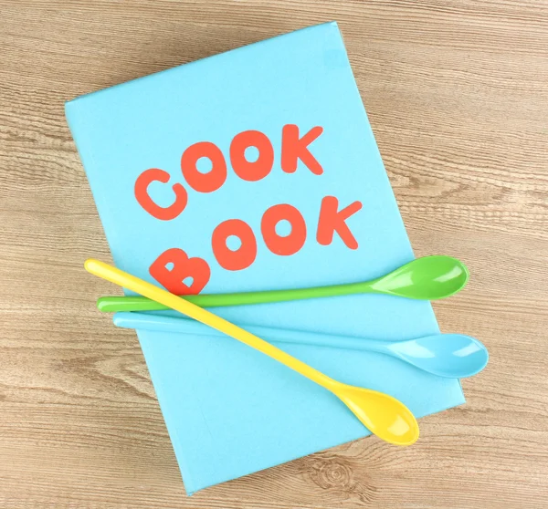 Livro de receitas e utensílios de cozinha sobre fundo de madeira — Fotografia de Stock