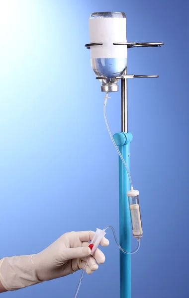 Infermiera che fa infusione su sfondo blu — Foto Stock