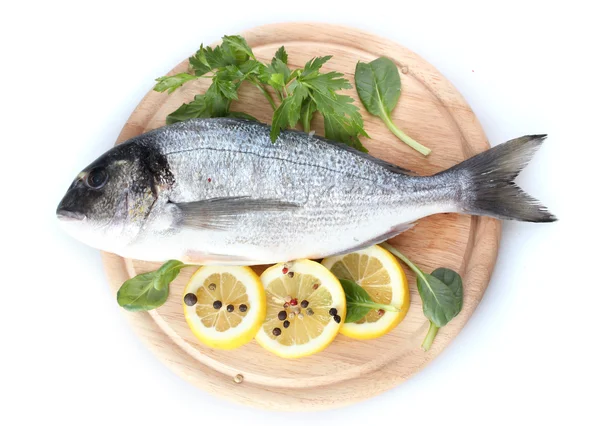 Čerstvé ryby s citronem, petržel a koření na dřevěné prkénko, izolované na bílém — Stock fotografie
