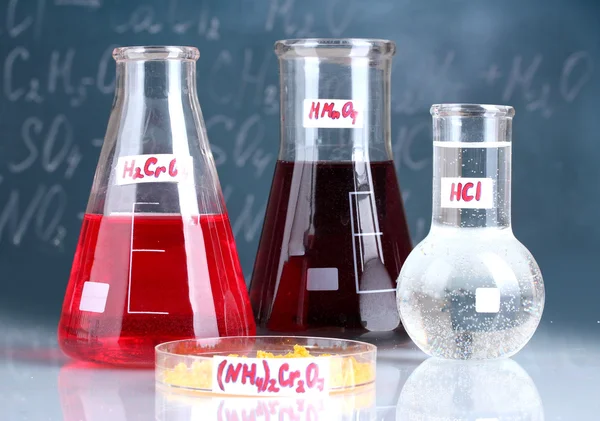 Test-tubes with various acids and other chemicals on the background of the blackboard — Stock Photo, Image