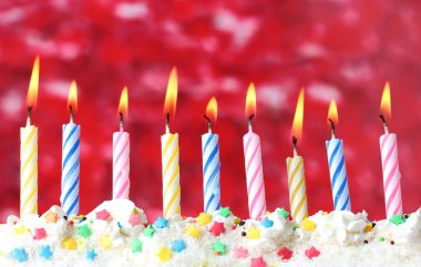 Beautiful birthday candles on red background clipart