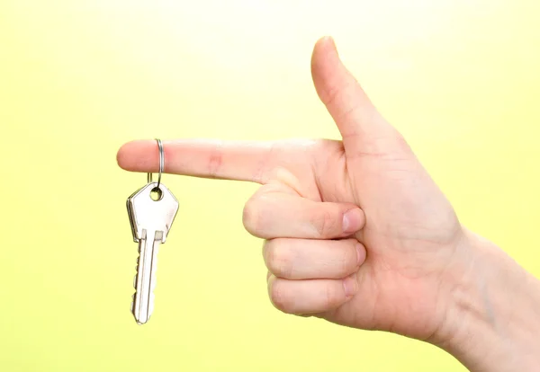Keys in hand on green background — Stock Photo, Image