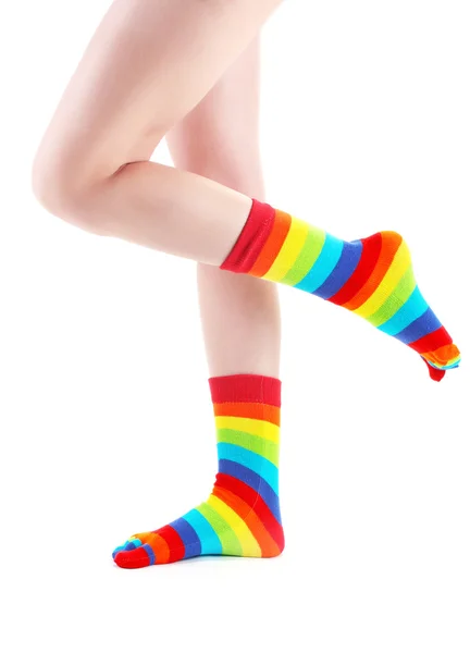 白で隔離されるカラフルなストライプ ソックスで女性の足 — ストック写真